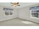 An empty bedroom with neutral colored walls and carpet and two windows at 8615 Arthur Hills Cir, North Charleston, SC 29420
