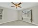 An empty bedroom with neutral colored walls and carpet and a ceiling fan at 8615 Arthur Hills Cir, North Charleston, SC 29420