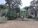 Quaint home with a green roof, surrounded by palm trees, mossy trees, and green grass and shrubbery at 1001 Jungle Shores Dr # 1/4 Share Interval, Edisto Beach, SC 29438