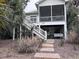 Charming coastal home with wooden stairs and lush tropical plants and fauna surrounding the house at 1001 Jungle Shores Dr # 1/4 Share Interval, Edisto Beach, SC 29438