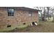 Brick house with outdoor access, showing foundation vents, and a partial view of the surrounding yard and landscape at 1097 Murrell Block Dr, Pineville, SC 29468