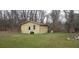 A yellow outbuilding, with a brick wall and a well pump on a lawn at 1097 Murrell Block Dr, Pineville, SC 29468