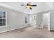 View of a spacious bedroom with a ceiling fan, two windows, and doors to the bathroom and closet at 113 Hartley Hall Ct, Summerville, SC 29485