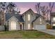 Charming two-story home with a well-maintained lawn and a two-car garage, seen at dusk at 113 Hartley Hall Ct, Summerville, SC 29485