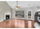 Inviting living room with brick fireplace, wood floors, large window, and staircase access at 113 Hartley Hall Ct, Summerville, SC 29485