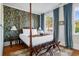 Spacious bedroom features a canopy bed, vintage wallpaper, and natural light, offering a serene and stylish retreat at 12 Percy St, Charleston, SC 29403