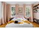 Cozy bedroom features two windows, bedside tables, and a king bed with a soft yellow throw blanket at 12 Percy St, Charleston, SC 29403