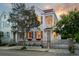 Charming two-story home featuring a wrought iron fence, second story porch, and a beautifully landscaped yard at 12 Percy St, Charleston, SC 29403
