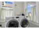 Convenient laundry room with a full-size washer and dryer, and two windows for natural light at 12 Percy St, Charleston, SC 29403