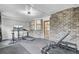 Home gym area featuring a brick accent wall, exercise equipment, and television at 1205 Scotch Pine Ln, Ladson, SC 29456