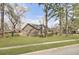 A well-maintained brick home with a green lawn and mature trees visible along the street at 1205 Scotch Pine Ln, Ladson, SC 29456