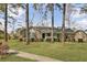 Traditional brick home featuring a cozy front porch and lush green lawn with mature trees at 1205 Scotch Pine Ln, Ladson, SC 29456