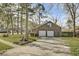 Brick home featuring a spacious driveway, two-car garage, manicured lawn and mature landscaping at 1205 Scotch Pine Ln, Ladson, SC 29456