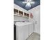 Functional laundry room with modern washer, dryer, overhead cabinets and ceiling fan with lighting at 1205 Scotch Pine Ln, Ladson, SC 29456