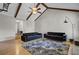 Bright living room featuring hardwood floors, dark sofas, area rug, and a vaulted ceiling with wooden beams at 1205 Scotch Pine Ln, Ladson, SC 29456