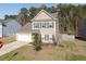 Charming two-story home with a manicured front yard and attached garage. The house has neutral siding and dark shutters at 122 Rockingham Way, Moncks Corner, SC 29461