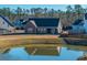 View of a screened-in porch from the backyard overlooking a serene pond and adjacent properties at 130 Darby Mdw Ln, Ridgeville, SC 29472