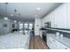 Modern kitchen boasts granite countertops, stainless steel appliances, and a seamless flow into the dining area at 130 Darby Mdw Ln, Ridgeville, SC 29472
