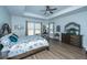 Main bedroom with tray ceiling features a large window and stylish furnishings, creating a serene retreat at 130 Darby Mdw Ln, Ridgeville, SC 29472