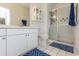 Well-lit bathroom with a glass-enclosed shower and blue-patterned floor mats at 130 River Landing Dr # 6207, Charleston, SC 29492