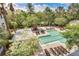 Aerial view of a community pool surrounded by lounge chairs, landscaping, and a grilling area under sunny skies at 130 River Landing Dr # 6207, Charleston, SC 29492