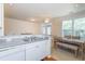 Bright kitchen with stainless steel sink and fixtures, granite countertops, white cabinets, and adjacent dining area at 130 River Landing Dr # 6207, Charleston, SC 29492