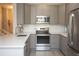 Bright kitchen features modern appliances, white herringbone backsplash and grey cabinetry at 130 River Landing Drive # 8209, Charleston, SC 29492