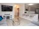 Stylish living room with open kitchen area featuring stainless steel appliances, gray cabinetry, and a breakfast bar at 130 River Landing Drive # 8209, Charleston, SC 29492