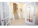 Hallway leading to a carpeted staircase with white risers and decorative French doors at 130 River Landing Drive # 8209, Charleston, SC 29492