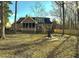 Large fenced backyard with mature trees, a fire pit, swing set, and a home with a screened porch at 132 Hidden Fawn Cir, Goose Creek, SC 29445