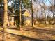 Backyard view of a brown home with a screened porch, swing set, and mature trees at 132 Hidden Fawn Cir, Goose Creek, SC 29445