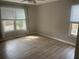 Bright bedroom with wood floors and two large windows looking out to the yard at 132 Hidden Fawn Cir, Goose Creek, SC 29445