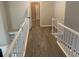 Upstairs hallway with neutral walls and floors featuring a decorative rug and white banister at 132 Hidden Fawn Cir, Goose Creek, SC 29445