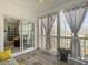 This screened porch has neutral curtains and a view from sliding glass doors to the living room at 138 Golfview Ln, Summerville, SC 29485