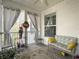 Cozy screened porch with a wicker couch and curtains, perfect for relaxing outdoors at 138 Golfview Ln, Summerville, SC 29485