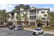 Three-story building featuring screened porches, palm trees, and front parking at 1505 Basildon Rd, Mount Pleasant, SC 29466
