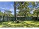 Large backyard with mature trees, lush lawn, and a rustic fire pit area, perfect for outdoor gatherings at 1520 Wakendaw Rd, Mount Pleasant, SC 29464