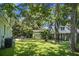 Expansive backyard with mature trees, lush lawn, and multiple outdoor seating areas for relaxing and entertaining at 1520 Wakendaw Rd, Mount Pleasant, SC 29464