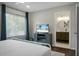 Bright bedroom featuring a bed with stylish pillows, tv on a console, and an open bathroom at 1520 Wakendaw Rd, Mount Pleasant, SC 29464
