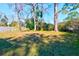 Large backyard featuring a lawn area with some bare spots and a privacy fence, surrounded by trees and greenery at 1556 Larry St, North Charleston, SC 29405