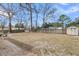 Spacious backyard with a large grassy area, bordered by a fence and trees, with shed in distance at 17 Anita Dr, Charleston, SC 29407