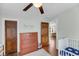 Bright bedroom featuring wood floors, a crib, a dresser, and a glimpse into the hallway at 17 Anita Dr, Charleston, SC 29407