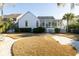Picture of a luscious backyard featuring an enclosed back porch, a stone walkway, manicured lawns, and mature landscaping at 184 Scott St, Daniel Island, SC 29492