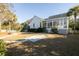 Picture of a luscious backyard featuring an enclosed back porch, a stone walkway, manicured lawns, and mature landscaping at 184 Scott St, Daniel Island, SC 29492