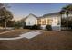 Expansive backyard featuring a sunroom, stone patio, and lush palm trees for outdoor relaxation and enjoyment at 184 Scott St, Daniel Island, SC 29492