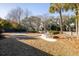 Serene backyard features manicured lawn, stone walkway, mature trees, and a tranquil seating area beneath shady trees at 184 Scott St, Daniel Island, SC 29492