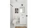 Cozy bathroom with white tile floor, framed art, and a shower with patterned curtain, offering a clean and functional space at 184 Scott St, Daniel Island, SC 29492