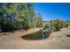 A lush backyard has a pond at the rear and is surrounded by tall trees at 1945 Hubbell Dr, Mount Pleasant, SC 29466