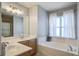 Bright bathroom featuring double sinks, a large mirror, vanity, soaker tub, and bright window at 1945 Hubbell Dr, Mount Pleasant, SC 29466