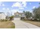 Lovely two-story home boasts a two-car garage, neutral siding, and a long, curved driveway at 2005 Nitsa St, Johns Island, SC 29455